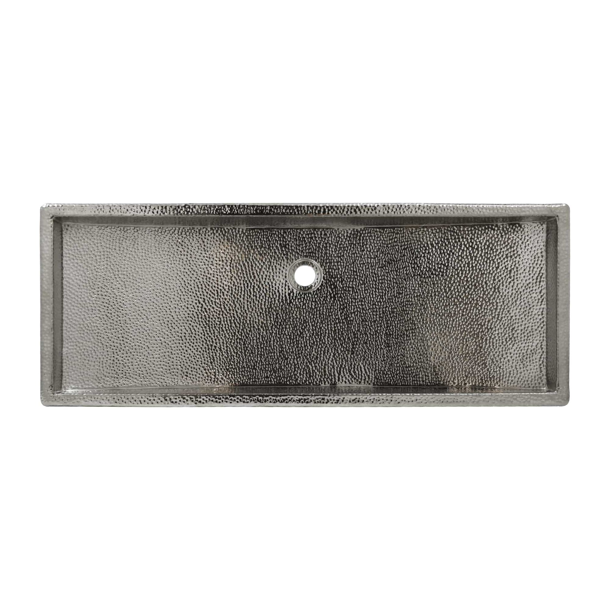 Polished nickel rectangular trough sink with textured interior surface and single drain hole.