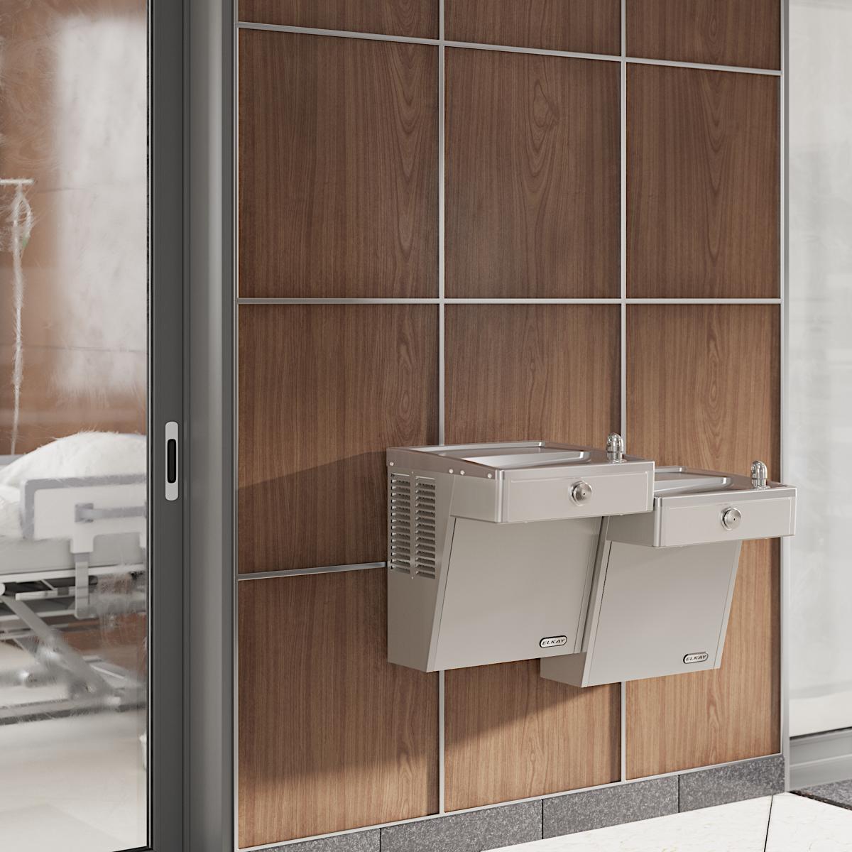 Stainless steel wall-mounted bi-level water cooler with two drinking fountains at different heights mounted on wood-paneled w