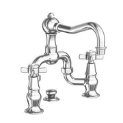 Chrome widespread bathroom sink faucet with curved spout, cross handles, and decorative base pedestals.
