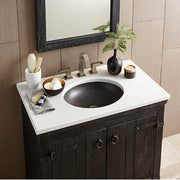 Slate-colored round bathroom sink mounted on white countertop with dark wood vanity cabinet and brushed nickel faucet.