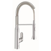 Chrome single-handle kitchen faucet with flexible coiled spray hose and tall arched spout.
