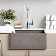 Ash gray rectangular farmhouse kitchen sink with chrome pull-down faucet, displayed in a countertop setting with white subway