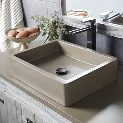 Rectangular cream-colored vessel sink with sloped interior walls and single drain hole, positioned on bathroom counter.