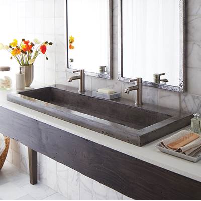 Rectangular ash-colored trough bathroom sink with dual chrome faucets mounted on marble countertop.
