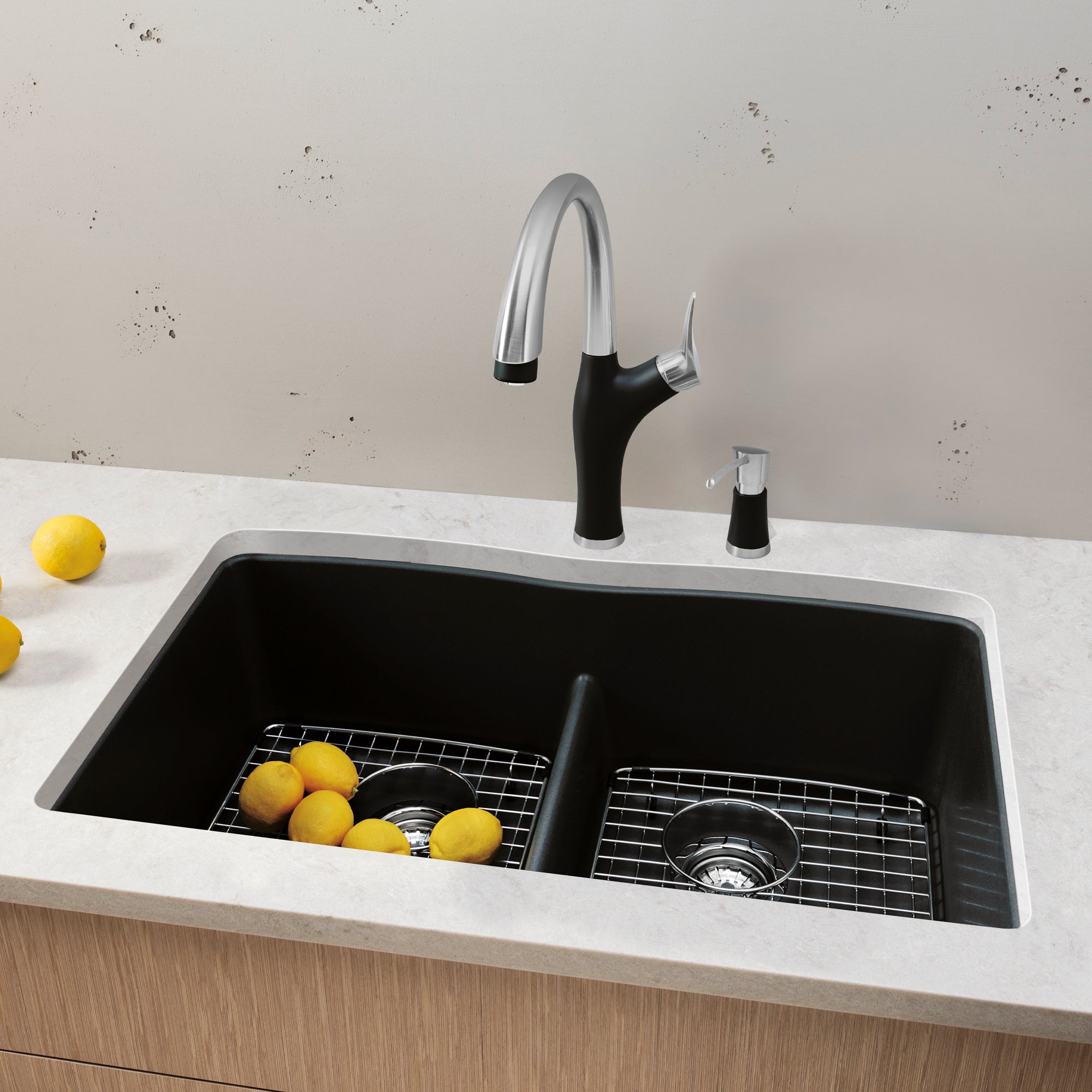 Anthracite double undermount sink with low divide, chrome pull-down faucet, and matching side sprayer installed in white coun