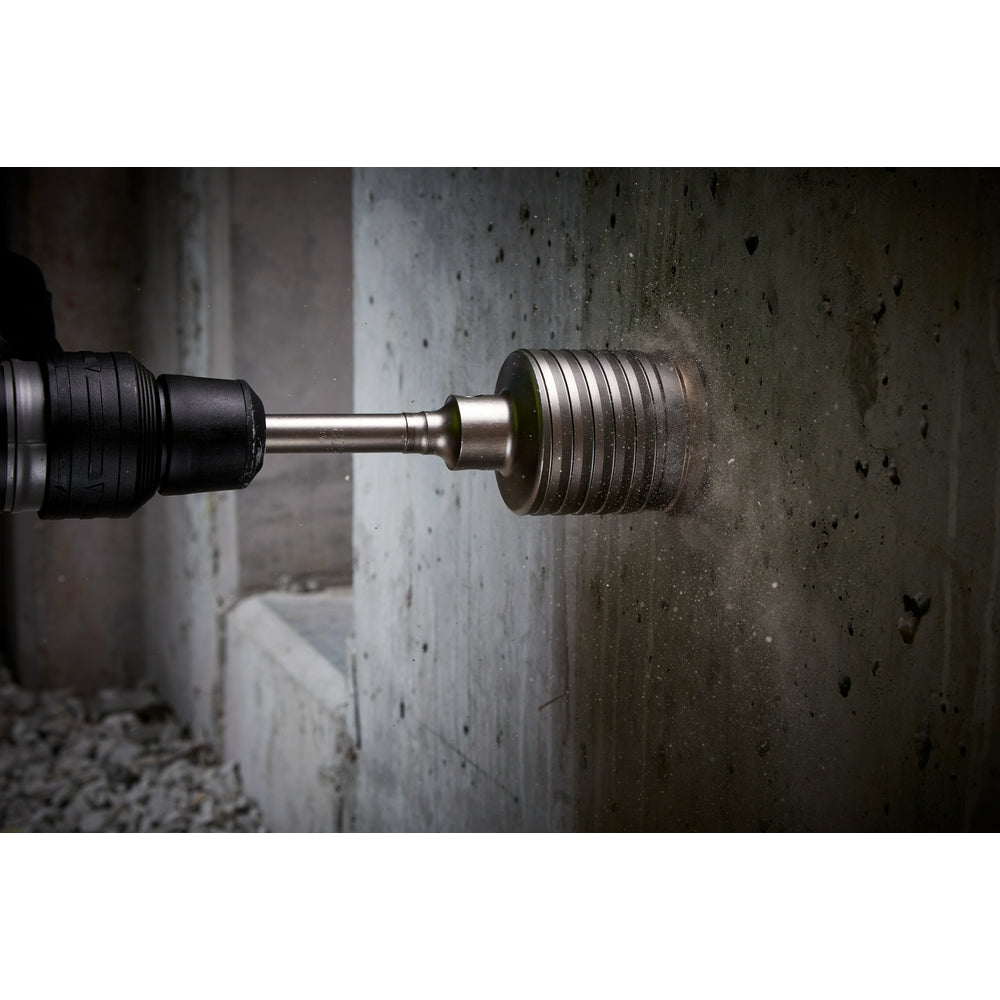 SDS-Max core bit with black rubber grip chuck on left side and grooved metal drilling head on right, positioned against concr