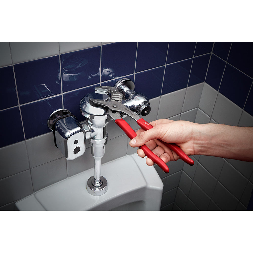 Milwaukee 12-inch smooth jaw locking plier with red handles being used on bathroom plumbing fixture.