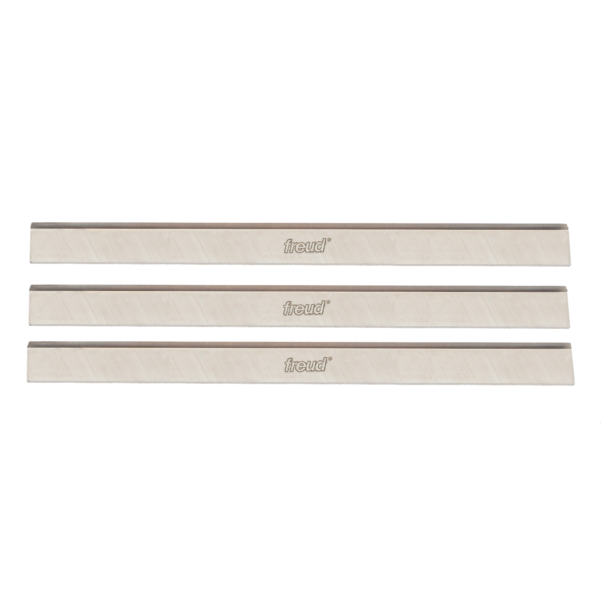 Three Freud high speed steel planer and jointer blades with gray cutting edges and cream-colored bodies.
