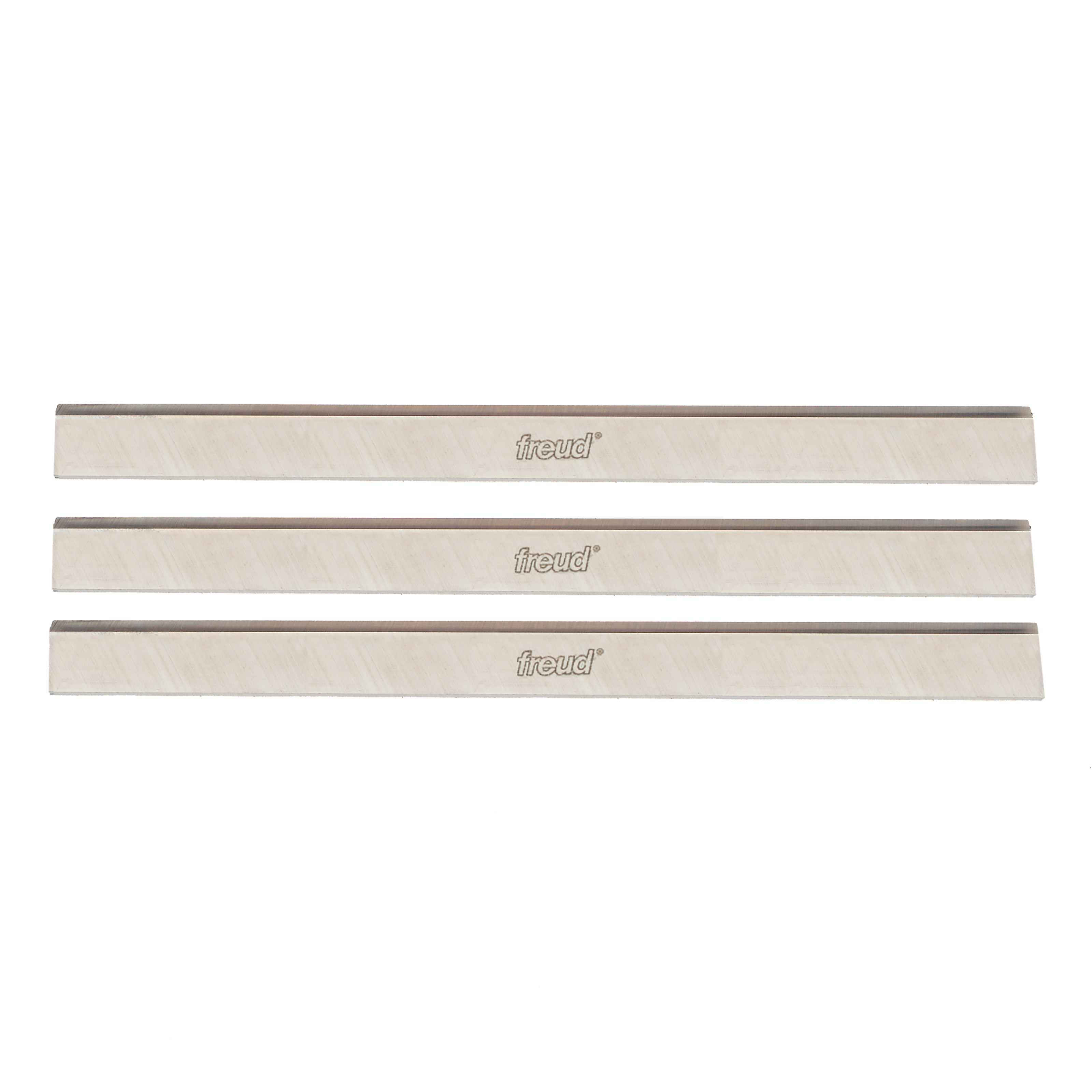 Three Freud high speed steel planer and jointer blades with gray cutting edges and cream-colored bodies.