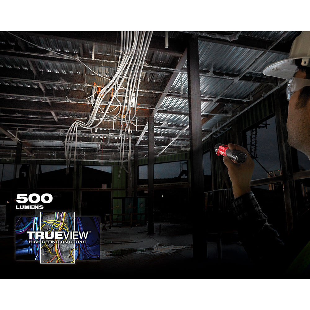 Red and black LED flashlight with pivoting head held in hand, illuminating electrical wires in an industrial setting.
