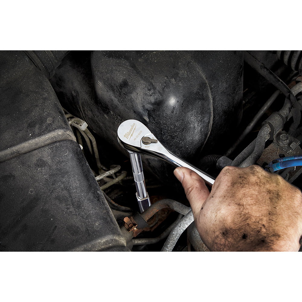 Milwaukee 3/8 in. drive ratchet with white head and chrome shaft held in hand over engine.