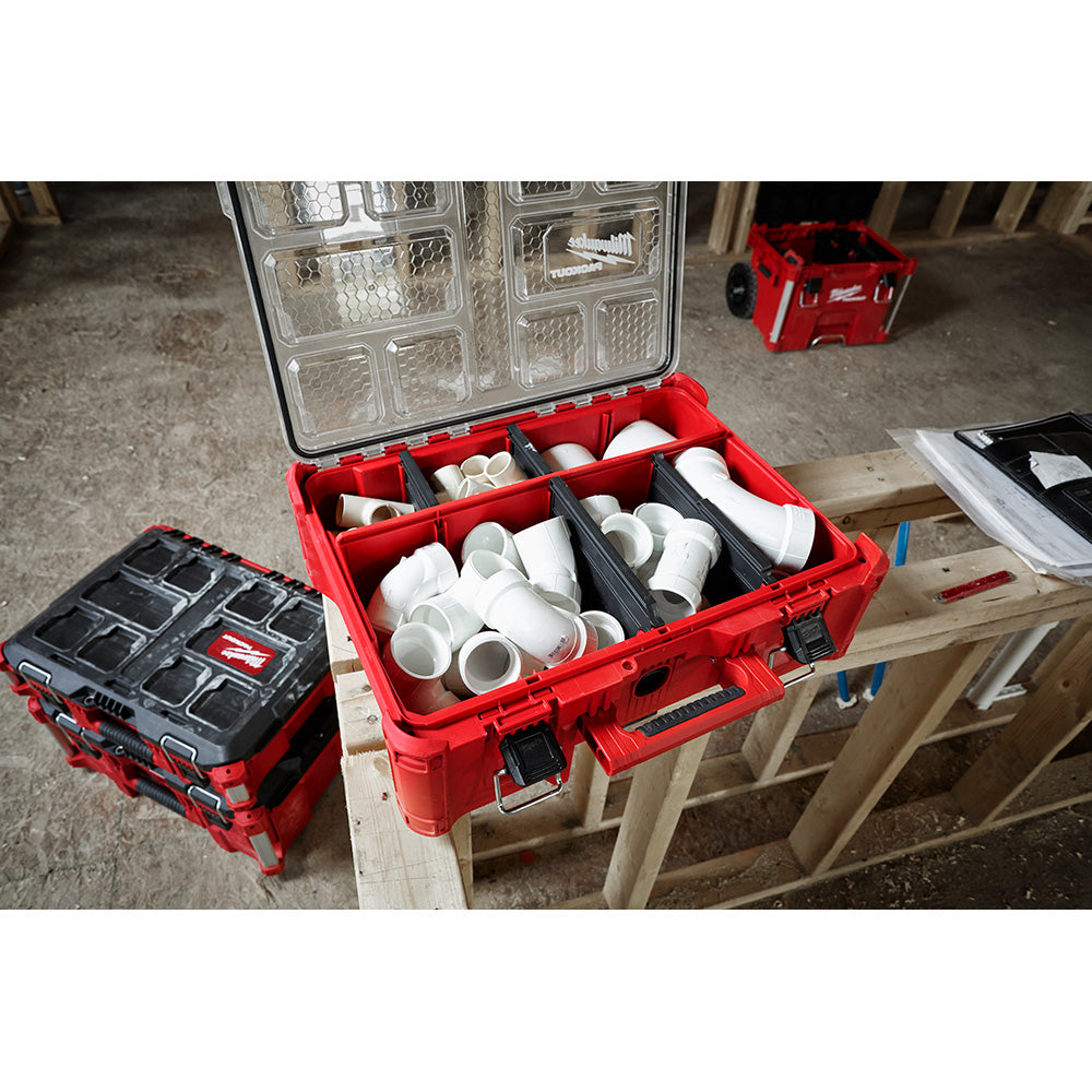 Red PACKOUT organizer with open lid displaying multiple compartments filled with white pipes and fittings.