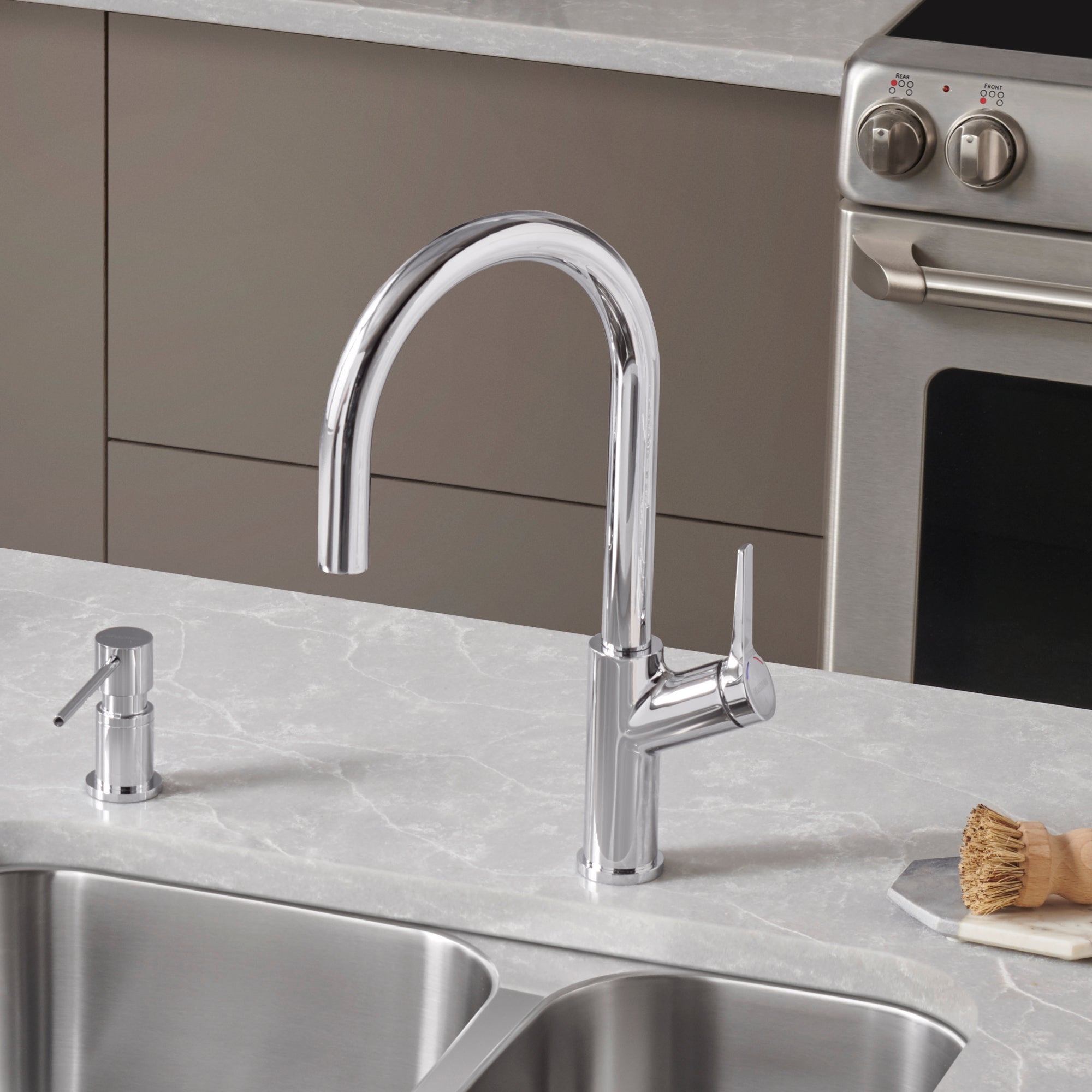 Chrome pull-down kitchen faucet with high curved spout and single lever handle mounted on white countertop above double sink.
