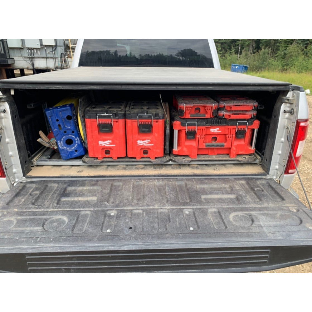 Red and blue tool organizers stacked in truck bed alongside other storage containers.
