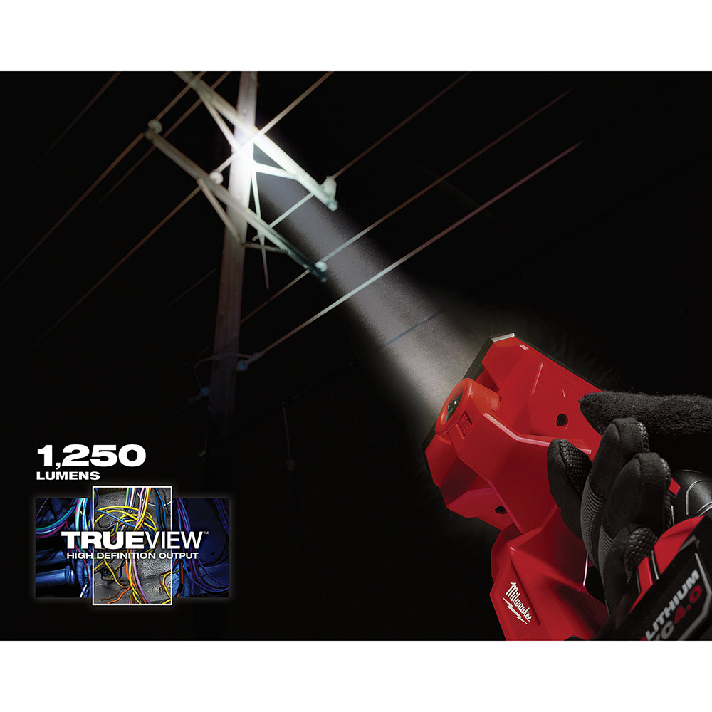 Red Milwaukee M18 search light with white LED beam illuminating power lines at night, rated 1,250 lumens.