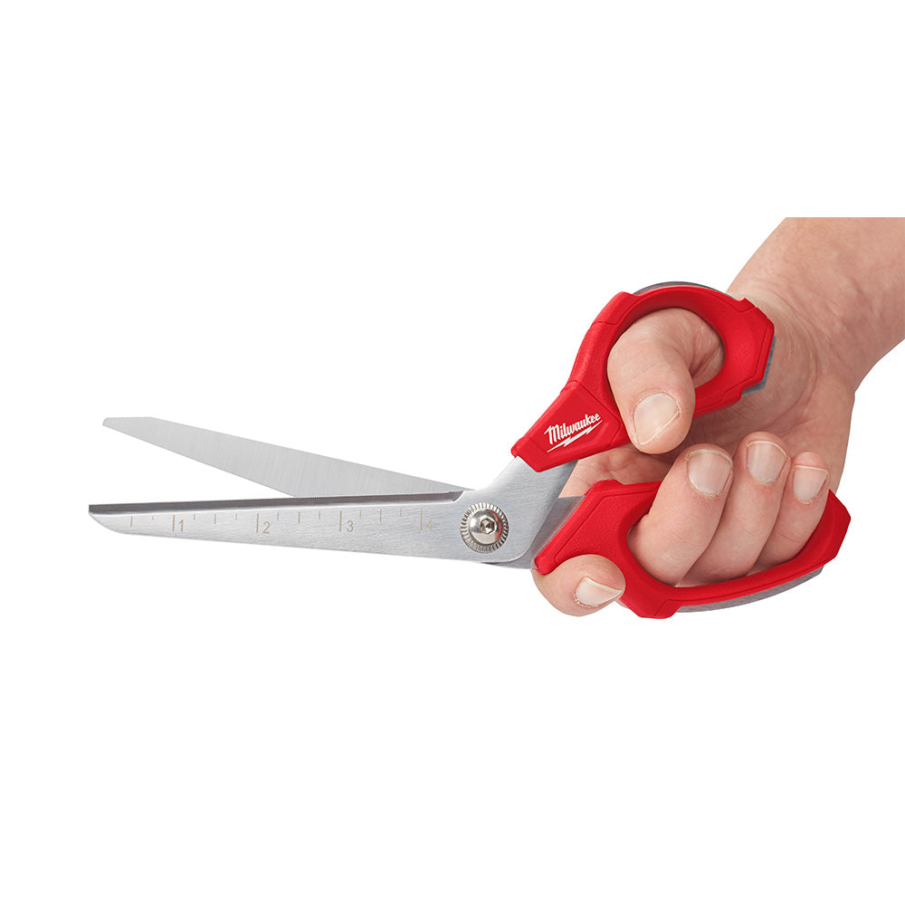 Milwaukee offset scissors with red handles held in hand, showing metal blades and measurement markings.