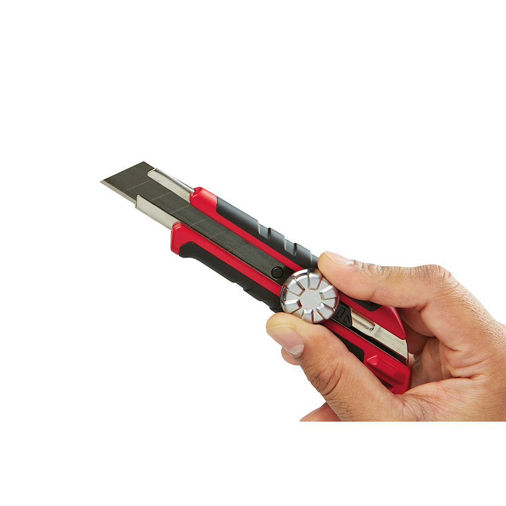 Red and black snap-off knife with metal lock mechanism held in hand, blade extended.