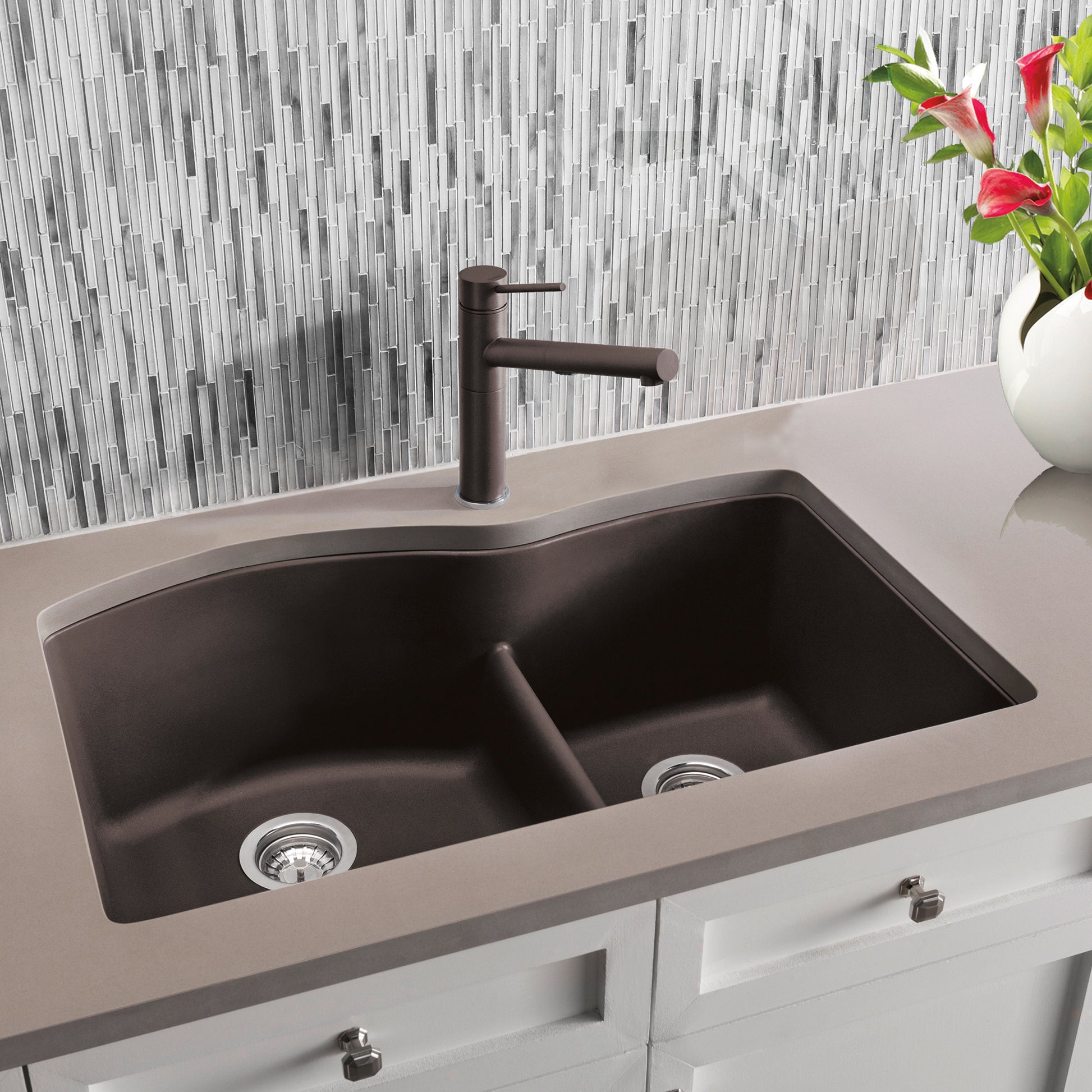 Cafe brown undermount double bowl kitchen sink with low divide and matching dark faucet installed in light countertop.