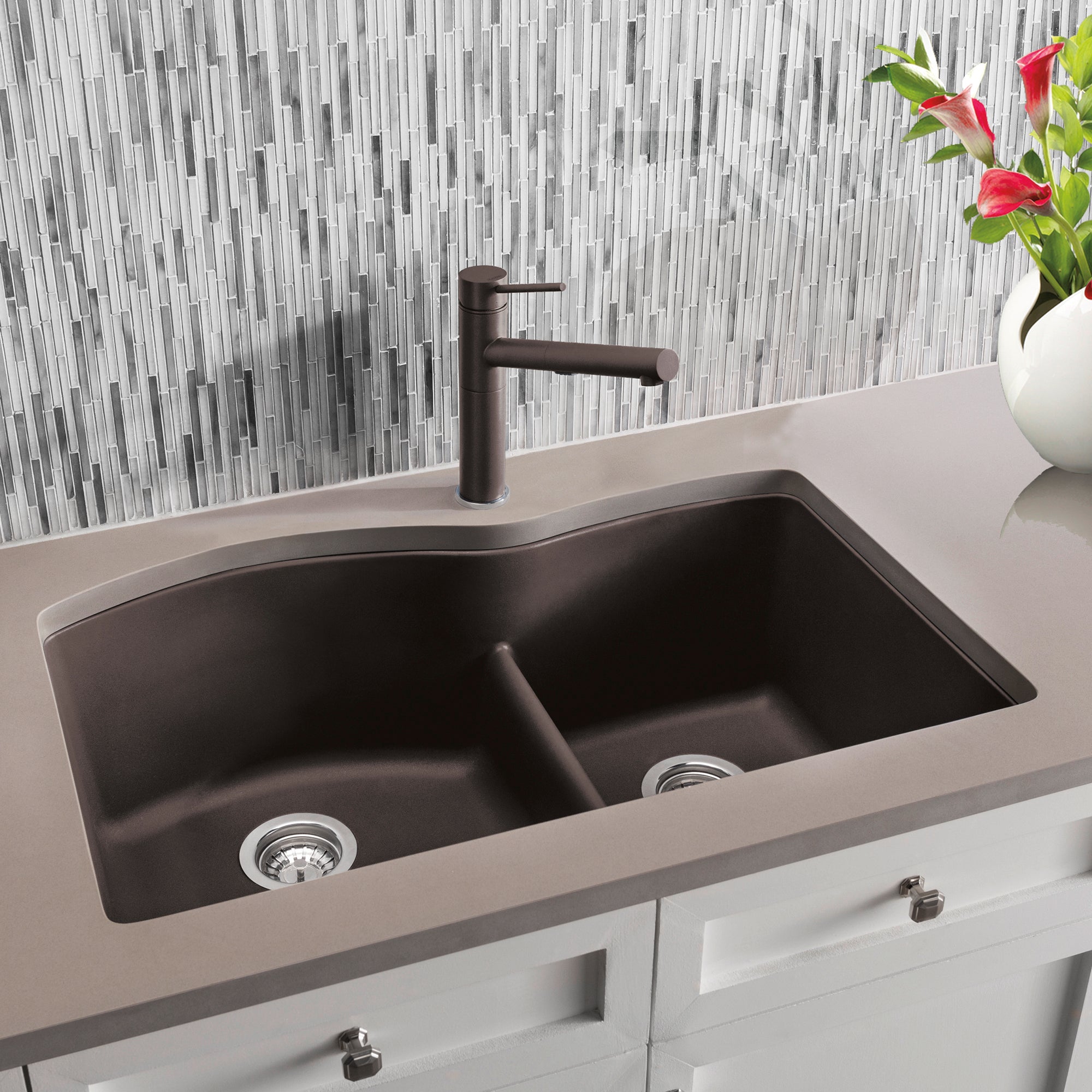 Cafe brown undermount double bowl kitchen sink with low divide and matching dark faucet installed in light countertop.