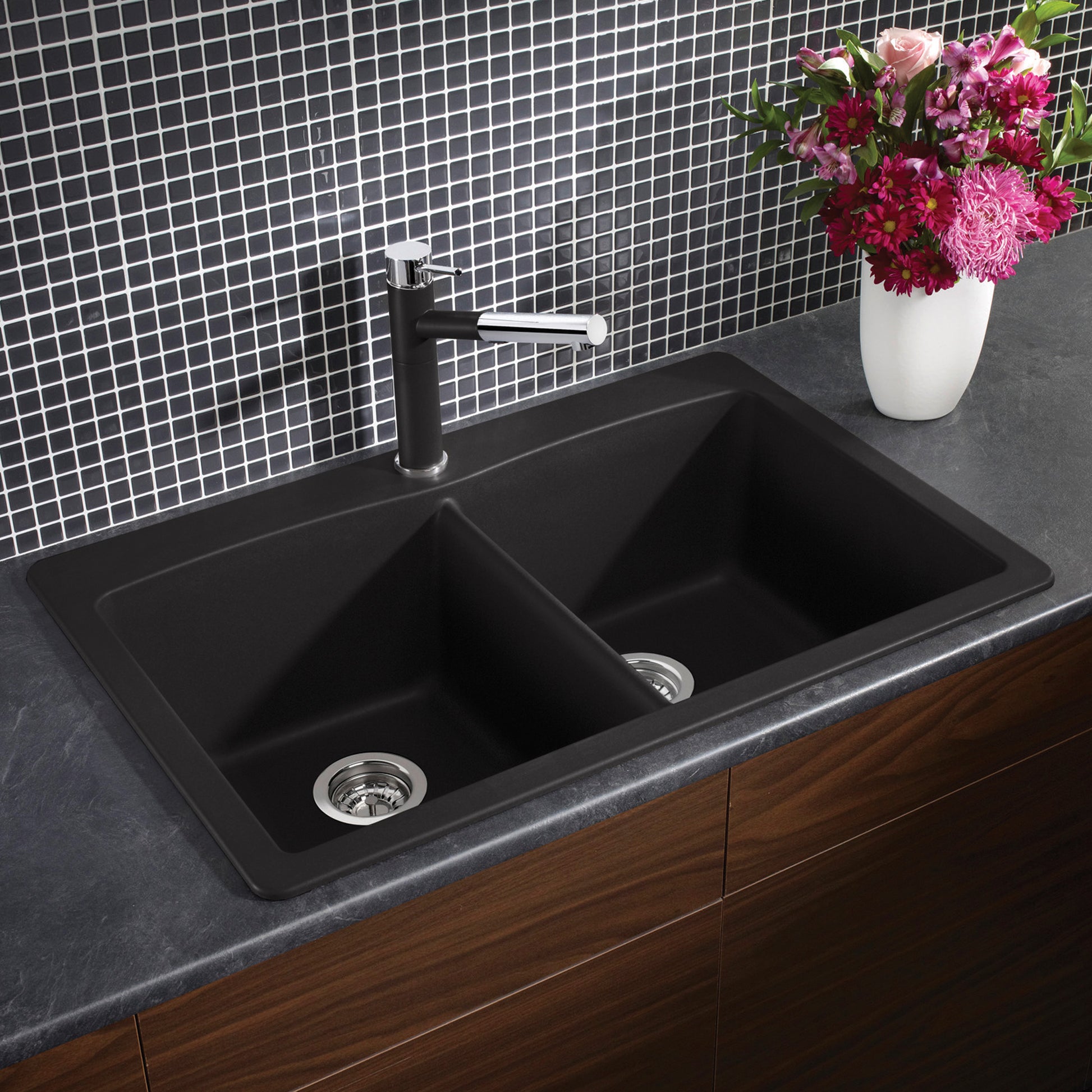 Anthracite double bowl drop-in kitchen sink with chrome faucet installed in dark countertop.