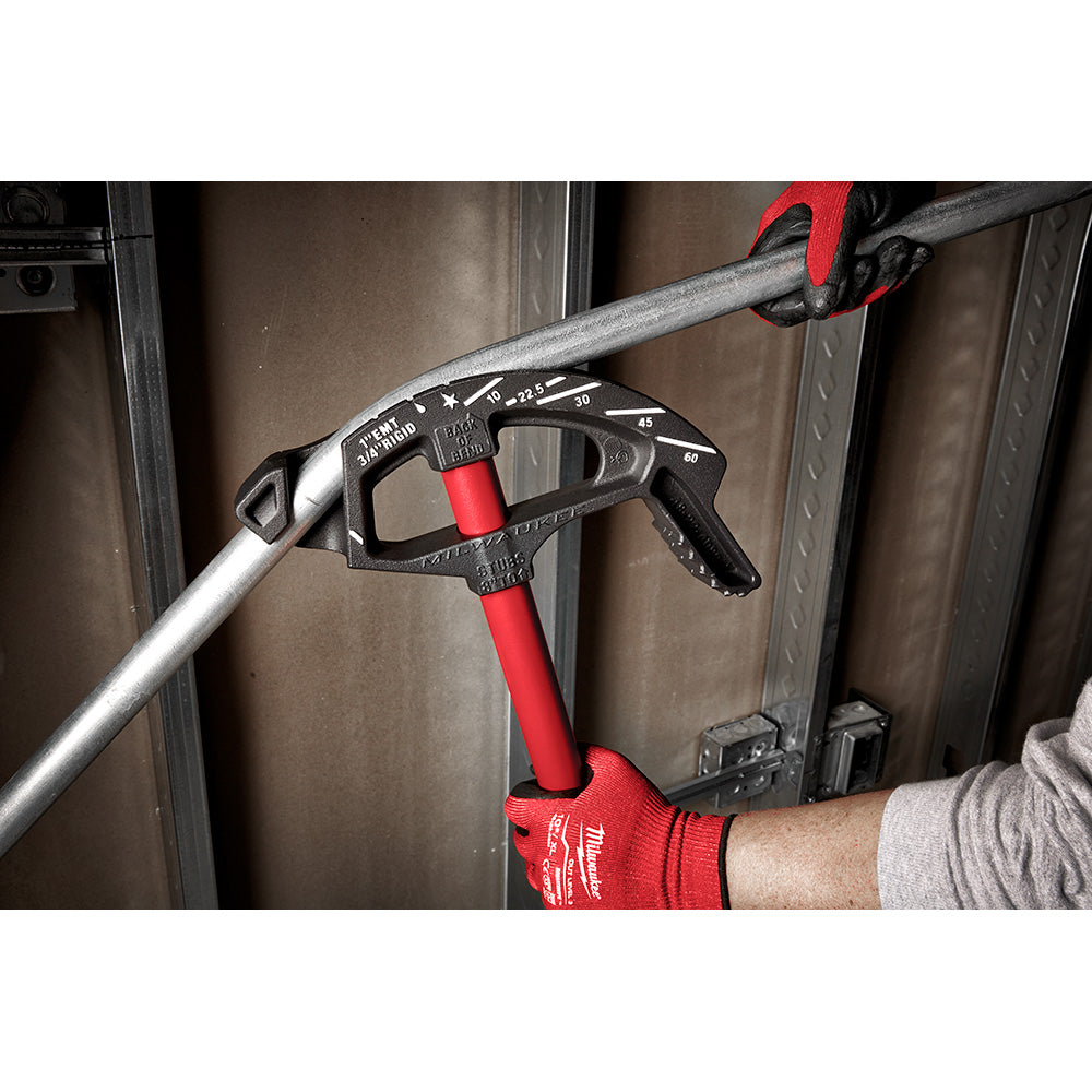 Black and red metal conduit bender with degree markings, held in use on galvanized conduit pipe.