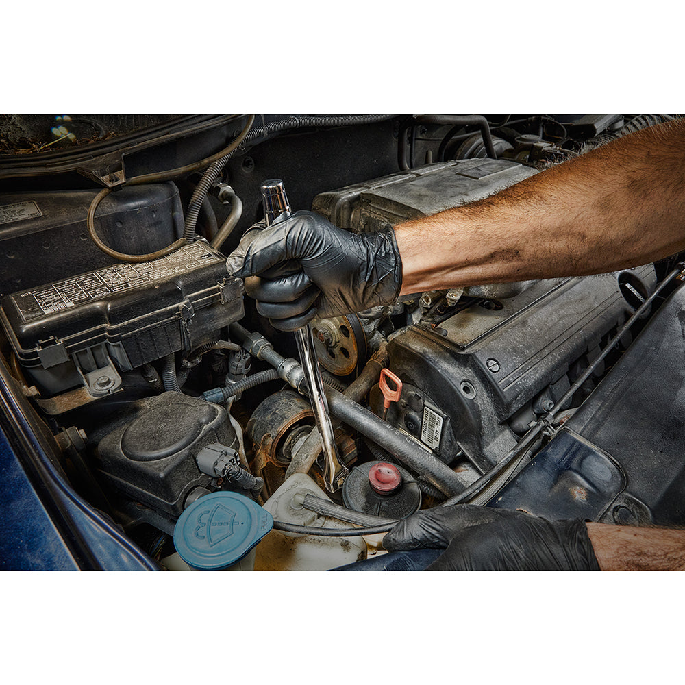 Black and chrome 1/2 inch drive breaker bar being used on an engine bolt by a person wearing gloves.