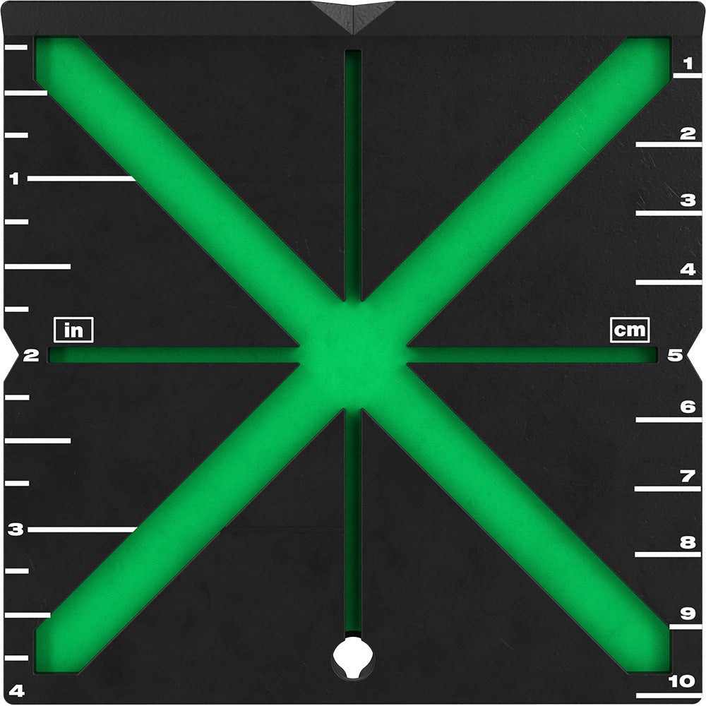 Black alignment target with bright green X-shaped crosshairs and measurement scales in inches and centimeters along the edges