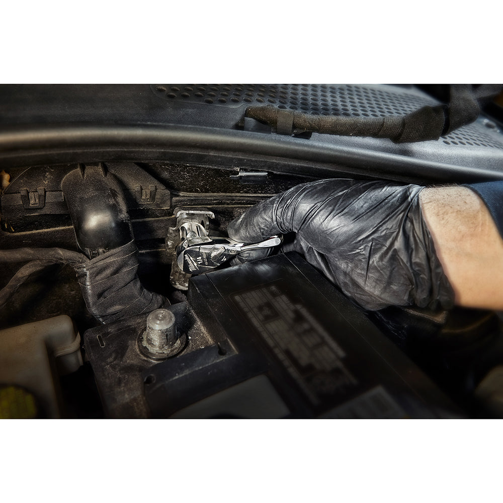Milwaukee 1/4" drive ratchet being used on automotive engine component by gloved hand.