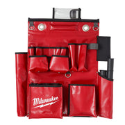 Red nylon tool apron with multiple pockets, metal D-rings, and black trim with transparent top compartment.