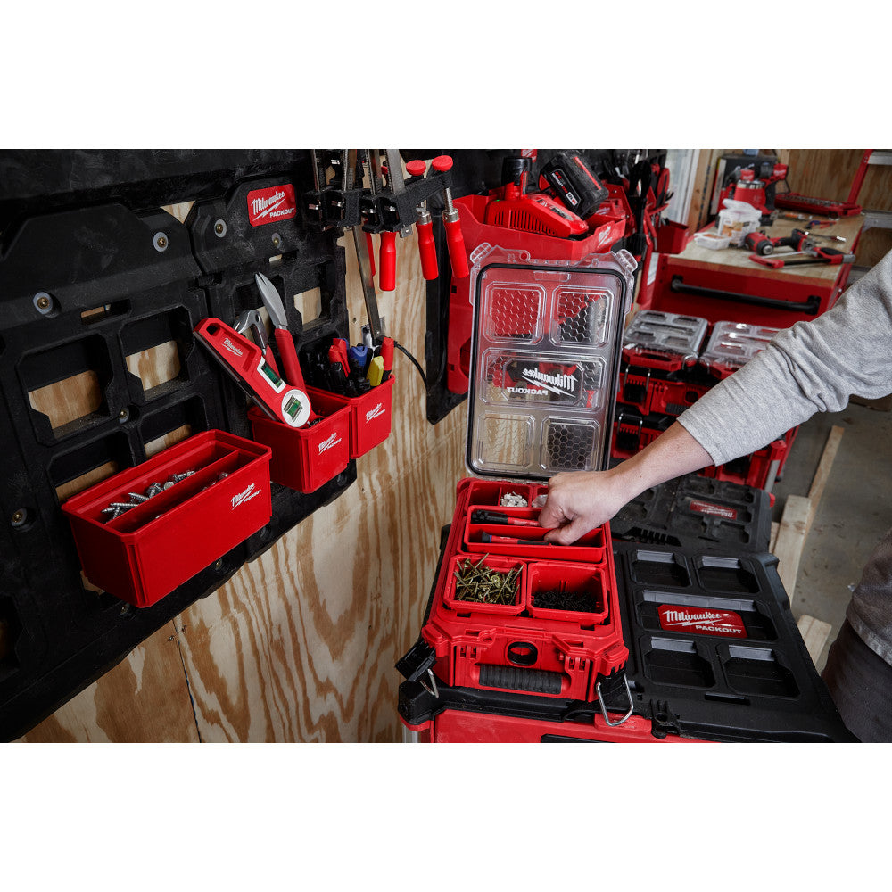 Two red and black Milwaukee PACKOUT storage bins with divided compartments, one open showing internal organizer trays.