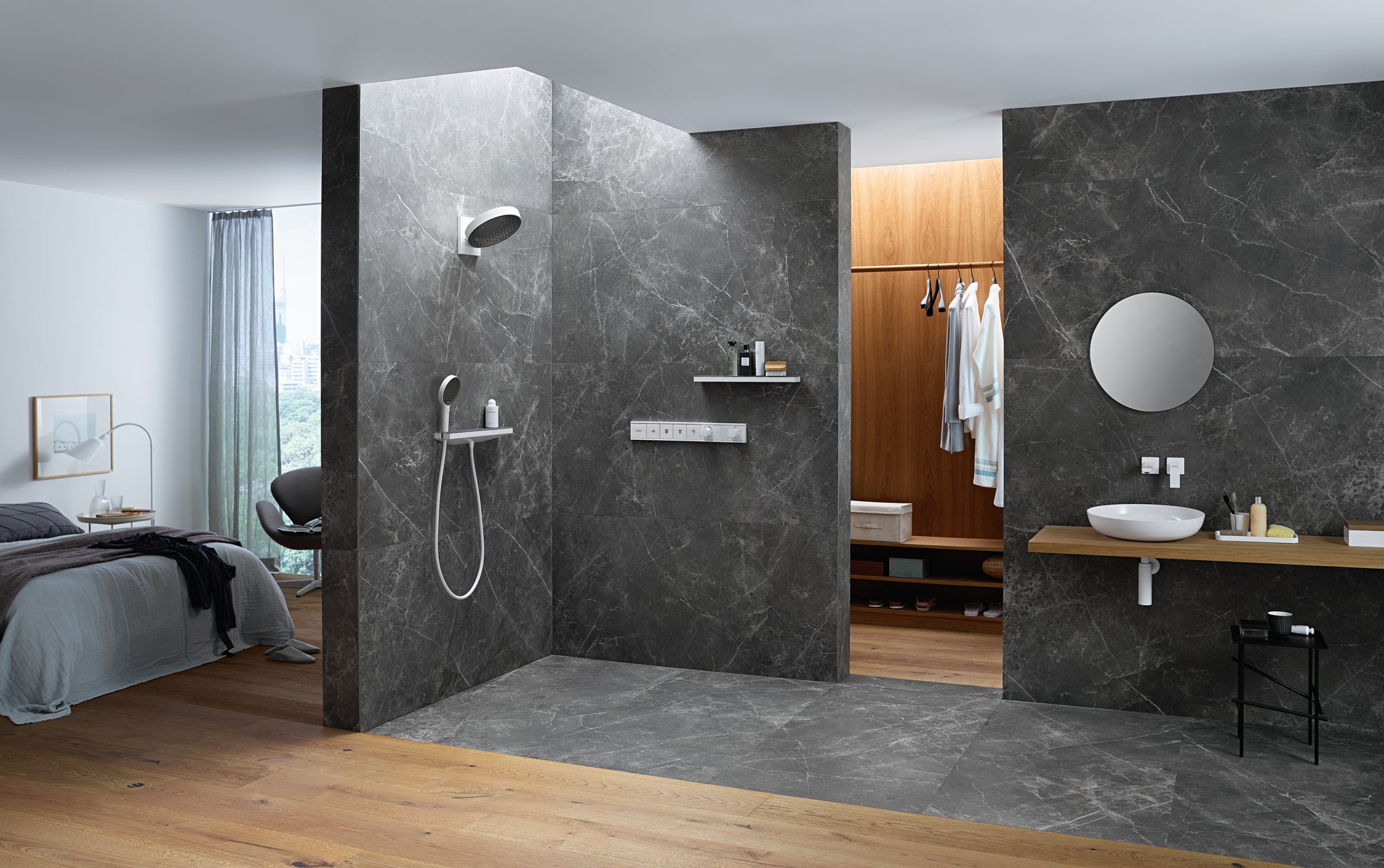 Matte white round shower head mounted on dark tile wall with handheld spray wand below.