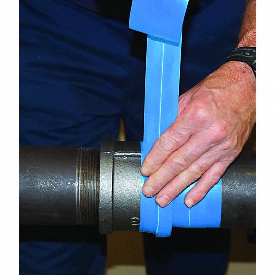 Blue compression seal tape being wrapped around a metal pipe fitting by a person's hand.