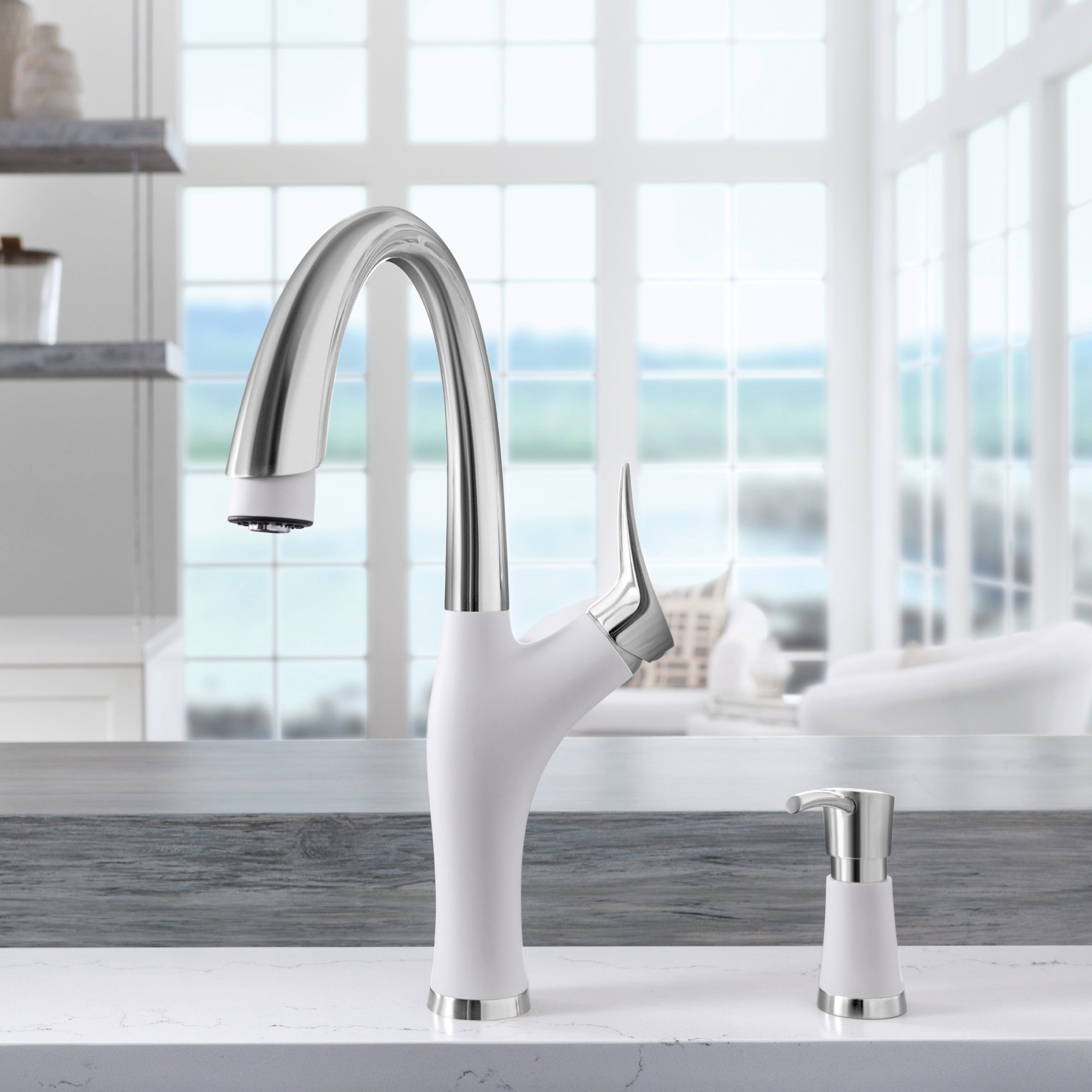 White and stainless steel pull-down kitchen faucet with curved spout and matching soap dispenser on countertop.