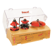 Three red router bits with black handles mounted on a wooden base in a clear plastic case labeled Freud.