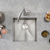 Stainless steel undermount bar sink with single basin and faucet hole, shown from above with styling accessories.