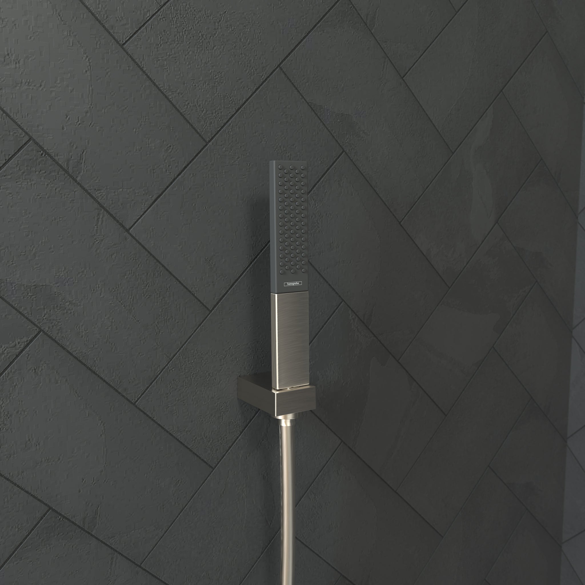 Brushed nickel rectangular handheld showerhead with perforated spray face mounted on a vertical hose against herringbone tile