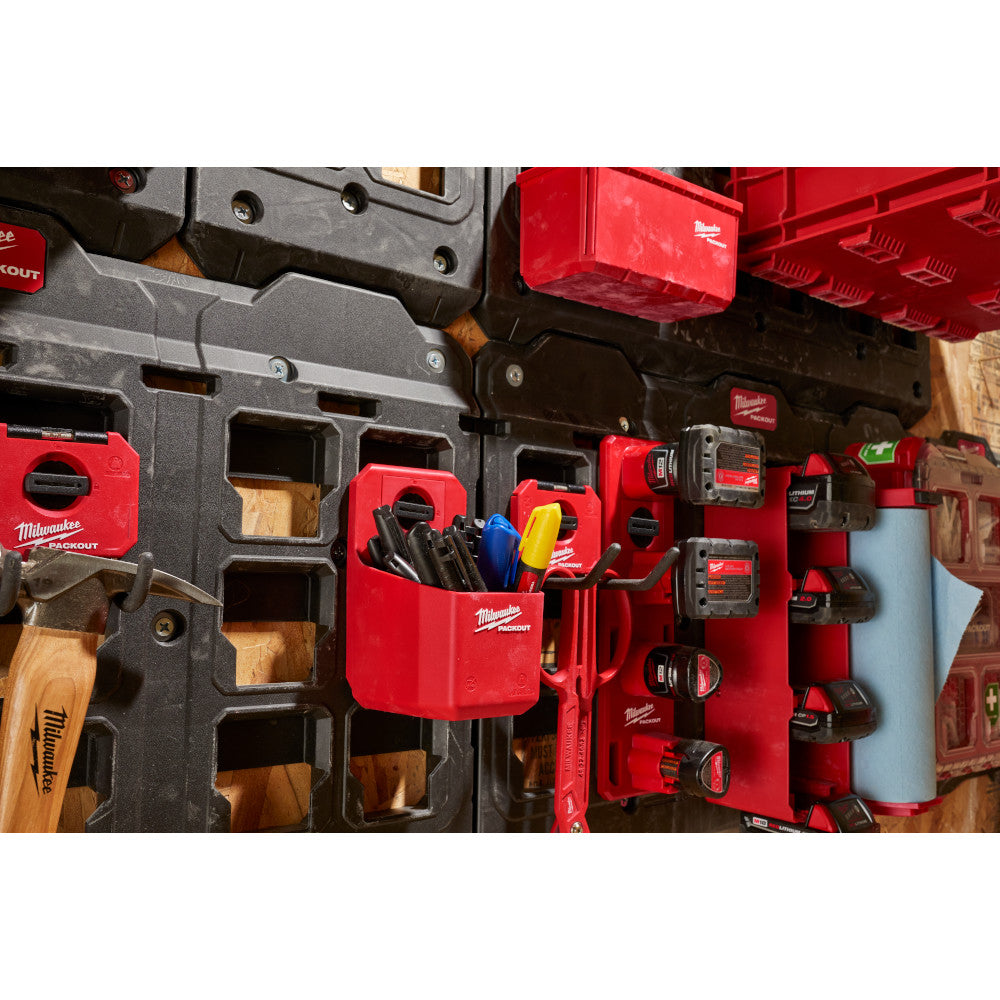 Red Milwaukee PACKOUT organizer cup holding tools, mounted on modular storage system with black and red compartments.