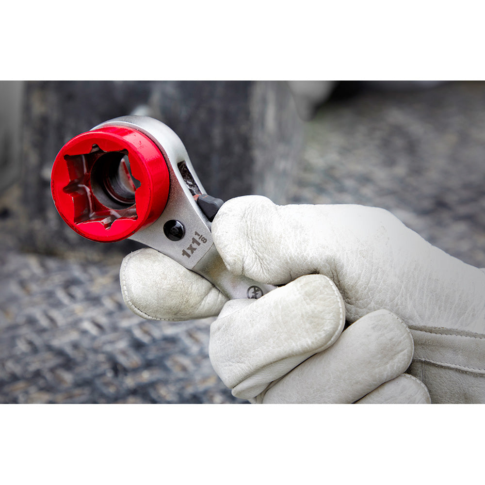 Milwaukee ratcheting wrench with red head and milled strike face held in work glove.
