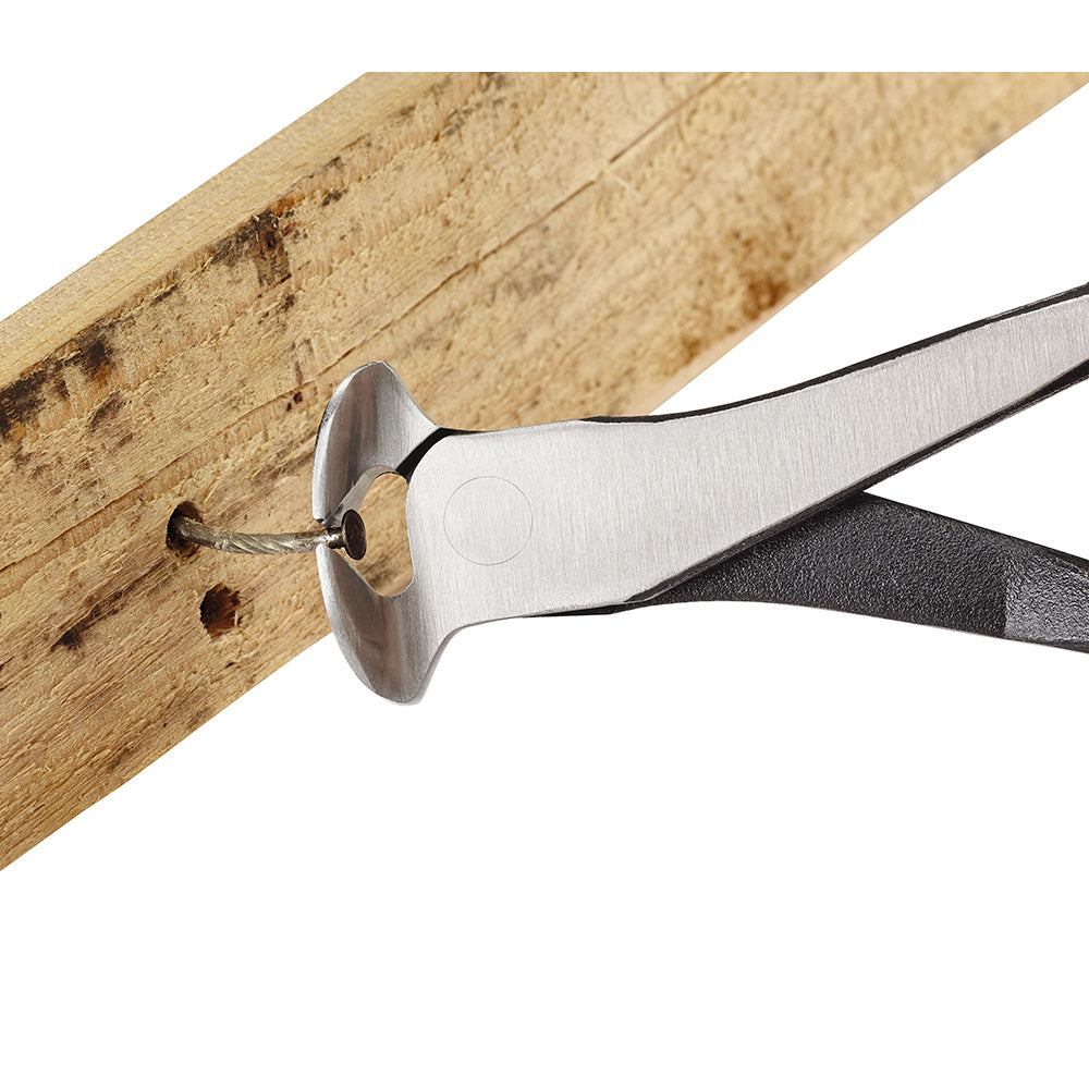 Nipping pliers with metal head and black handles cutting a nail from wood board.