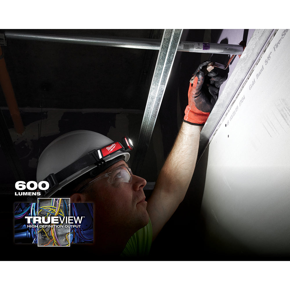 Black and red headlamp worn on head, illuminating interior ceiling work area with 600 lumens output.