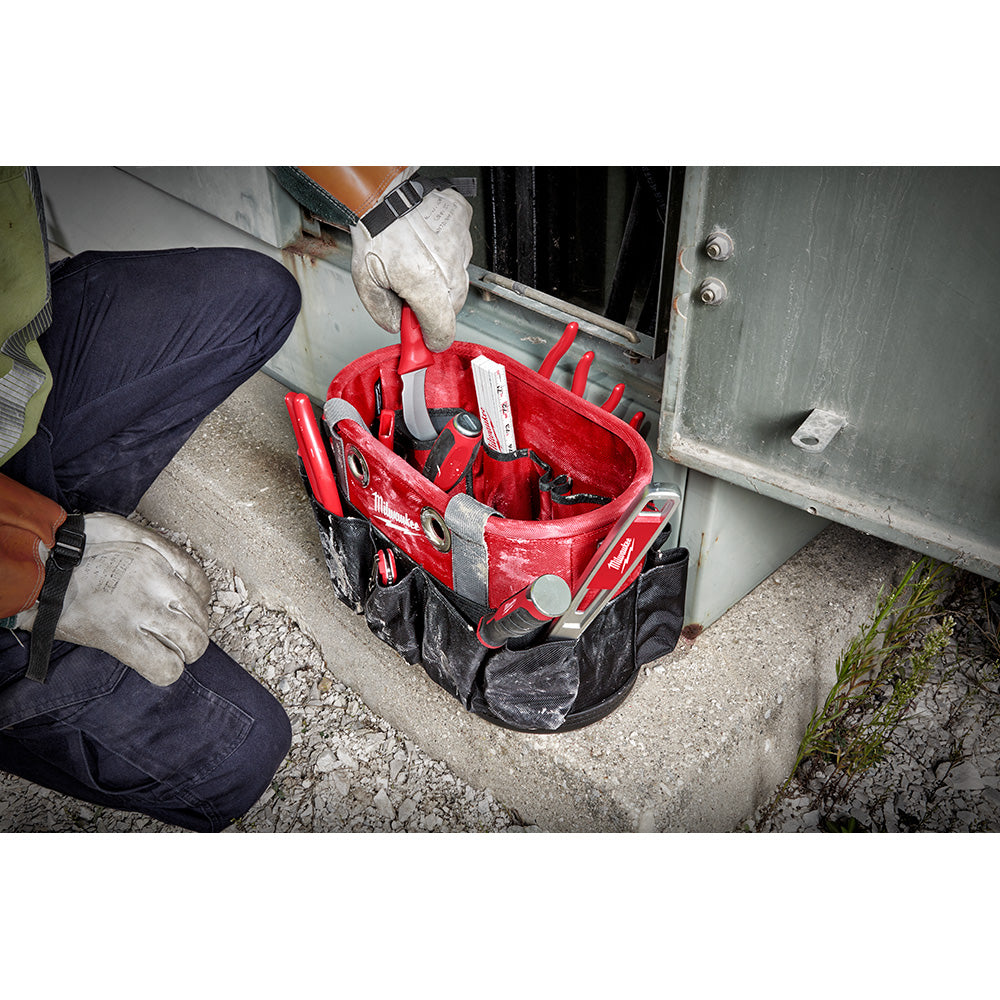Red and black oval tool bag with multiple compartments and carrying handles, filled with various tools and supplies.
