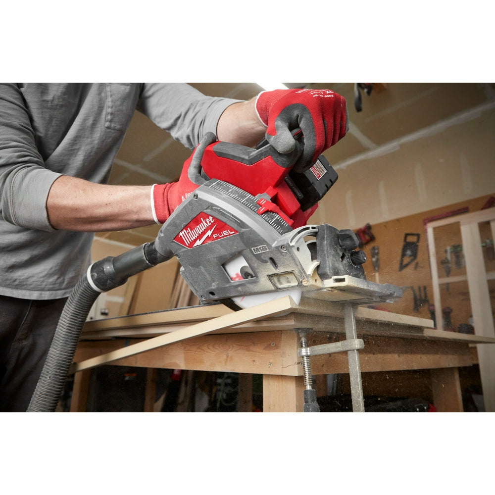 Milwaukee track saw blade mounted in tool with operator wearing red gloves cutting wood.