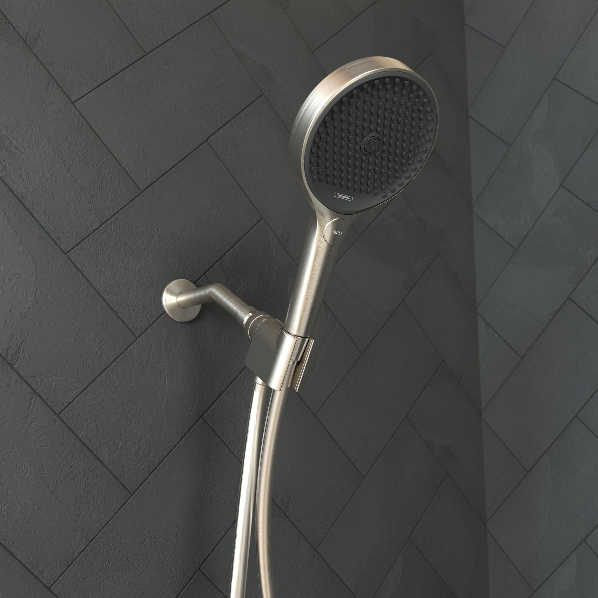 Brushed nickel handshower with round perforated face mounted on shower arm with adjustable holder against tiled wall.