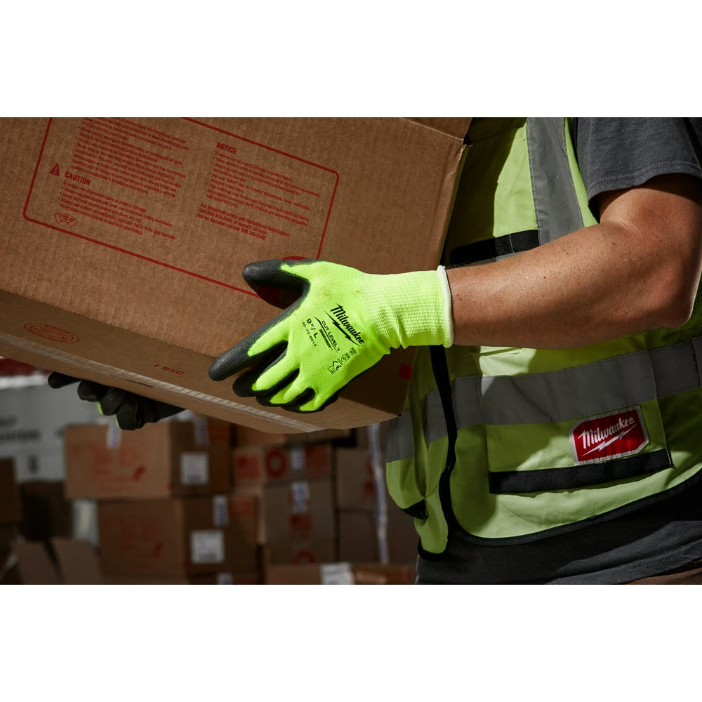 High-visibility yellow-green work gloves with black polyurethane-dipped palms being worn while holding a cardboard box.