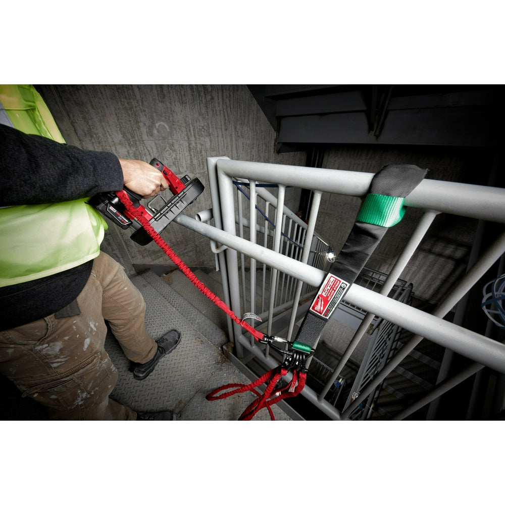 Red nylon anchor strap with black buckle and hardware being used to secure a metal railing.