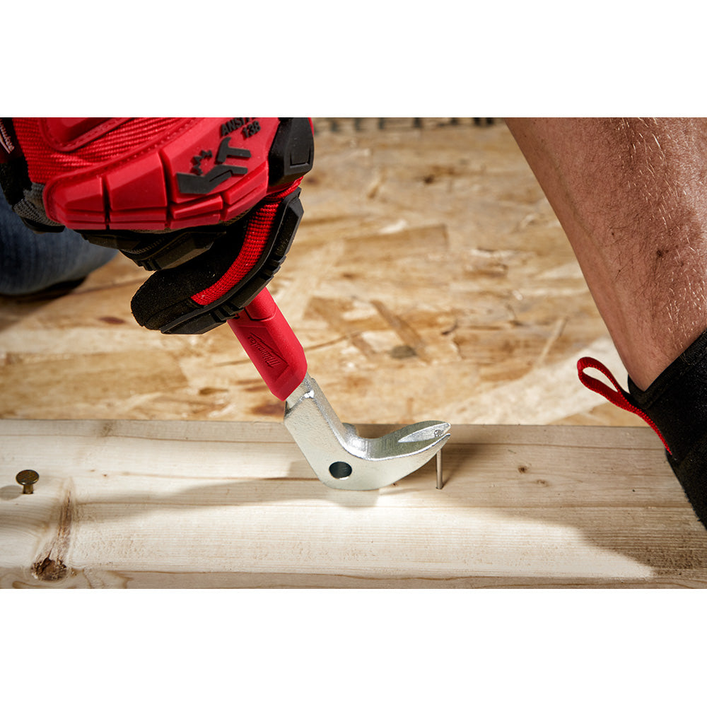 Red and black pry bar with curved claw end being used to remove a nail from wood flooring.