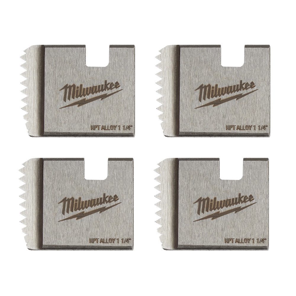 Four Milwaukee 1-1/4" NPT alloy pipe threading dies with serrated cutting edges and brand markings.