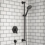 Matte black wall-mounted shower bar with handheld showerhead, valve control, and water outlet against white subway tile.
