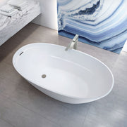 White oval freestanding soaker bathtub with deck-mounted filler in modern bathroom setting.