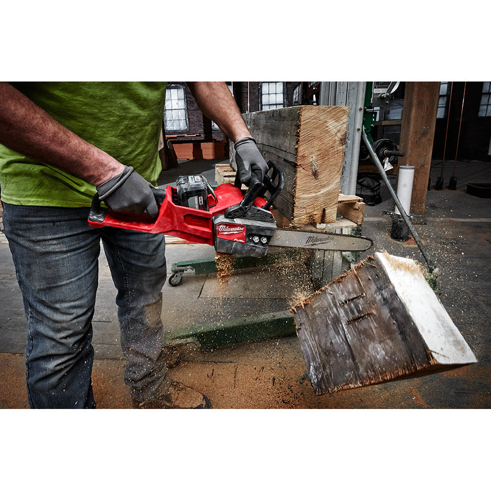 Milwaukee 14-inch chainsaw guide bar mounted on red cordless chainsaw being used to cut wood.
